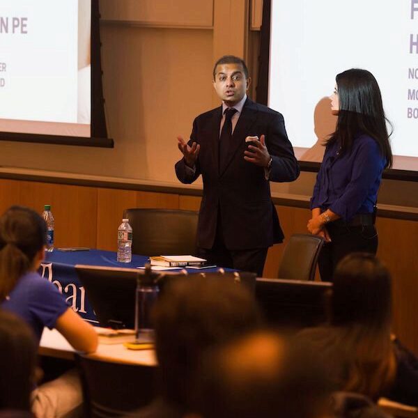 Sachin Khajuria addresses an audience, next to Burcu Esmer