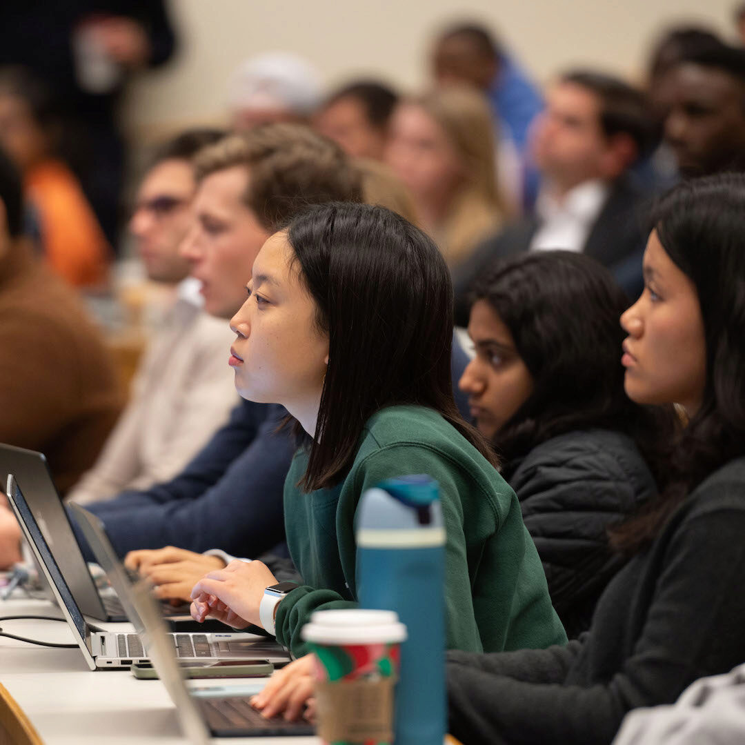 Audience members watch a presentation