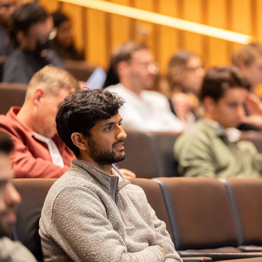 An audience member looks forward during a presentation in an auditorium