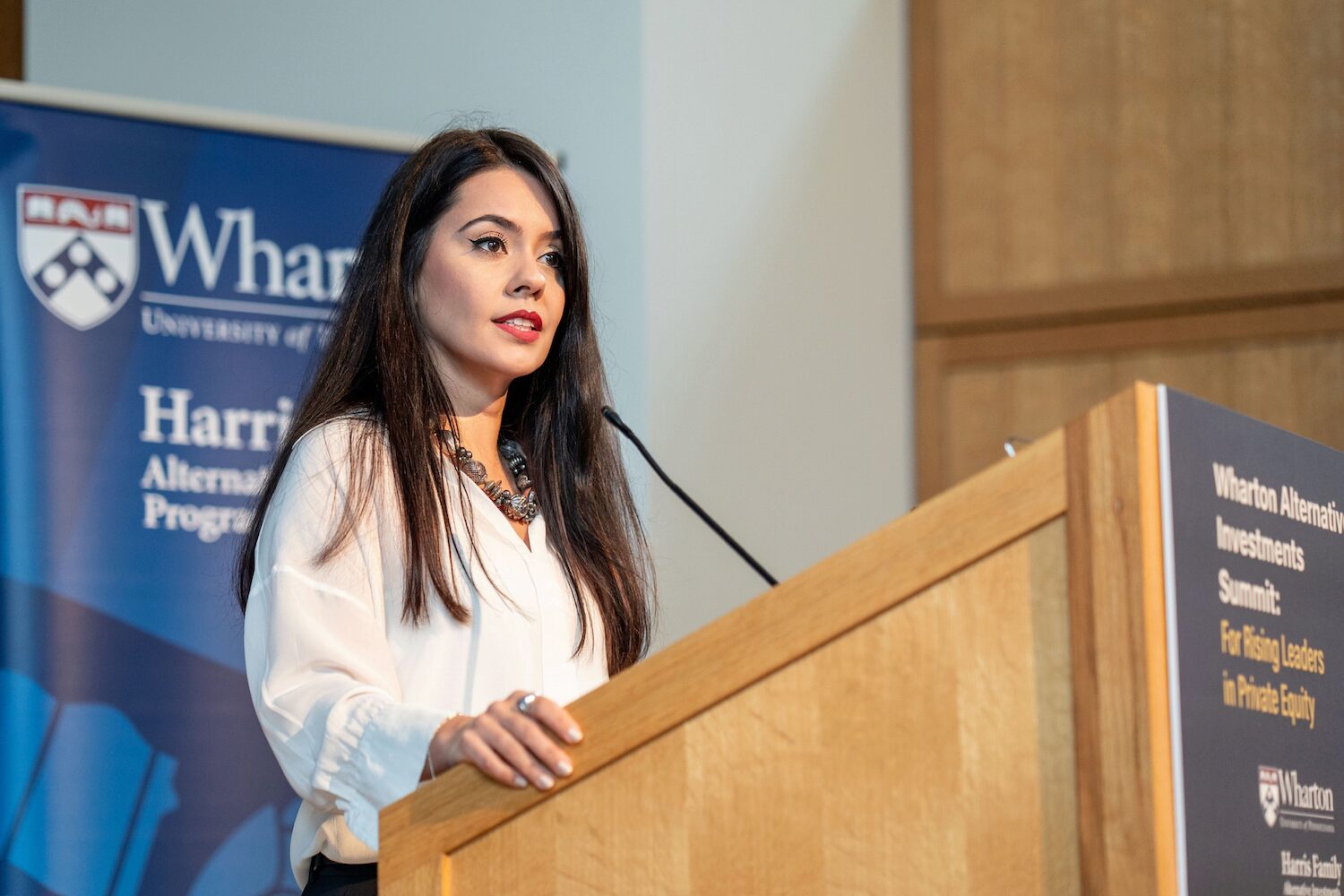 A presenter speaking into a microphone at a podium
