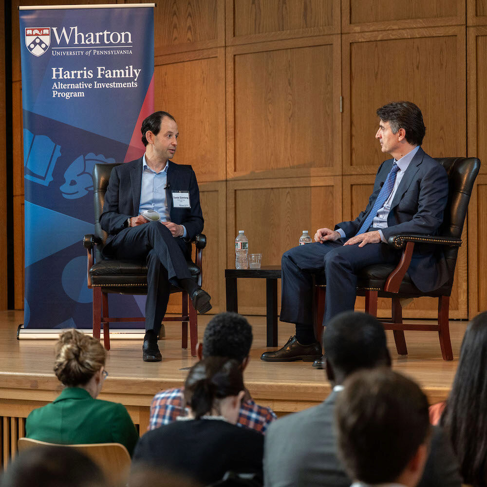 Two speakers onstage while seated