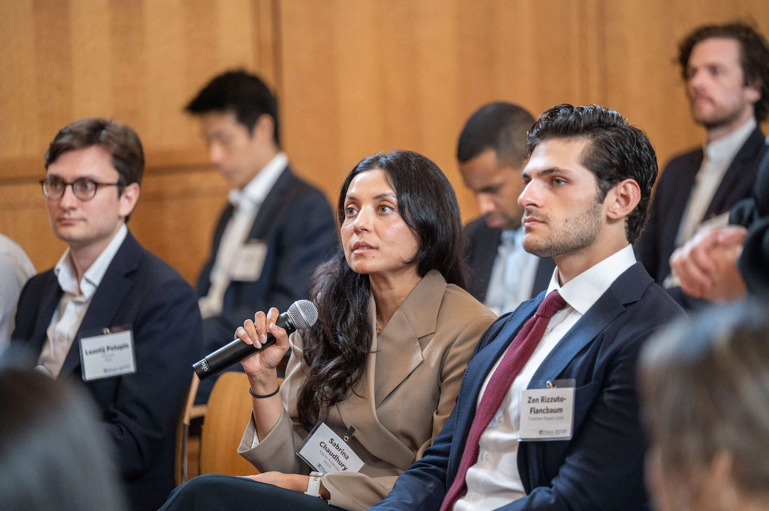 An audience member asks a question into a microphone in a conference setting