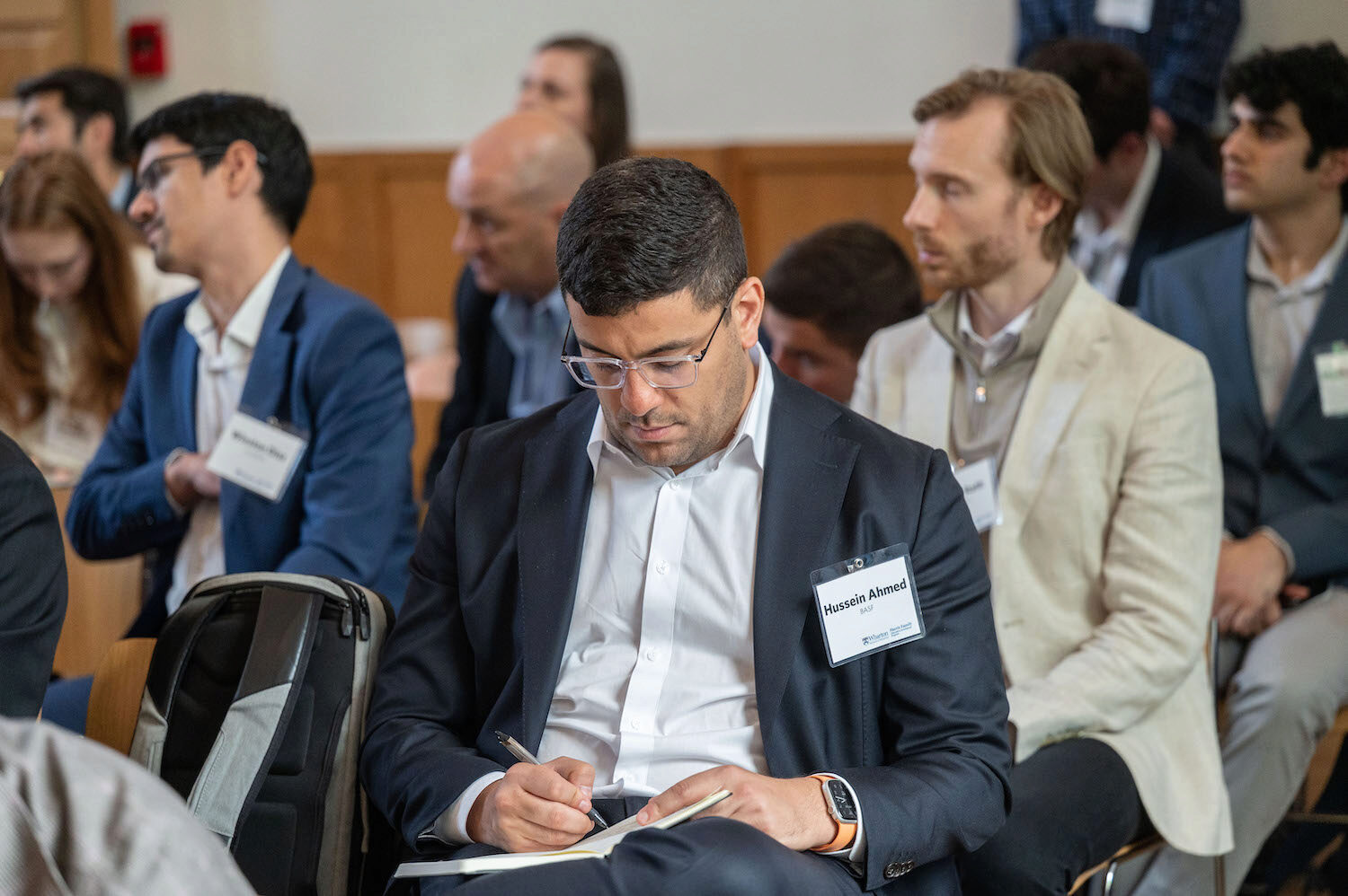 A conference attendee writes notes