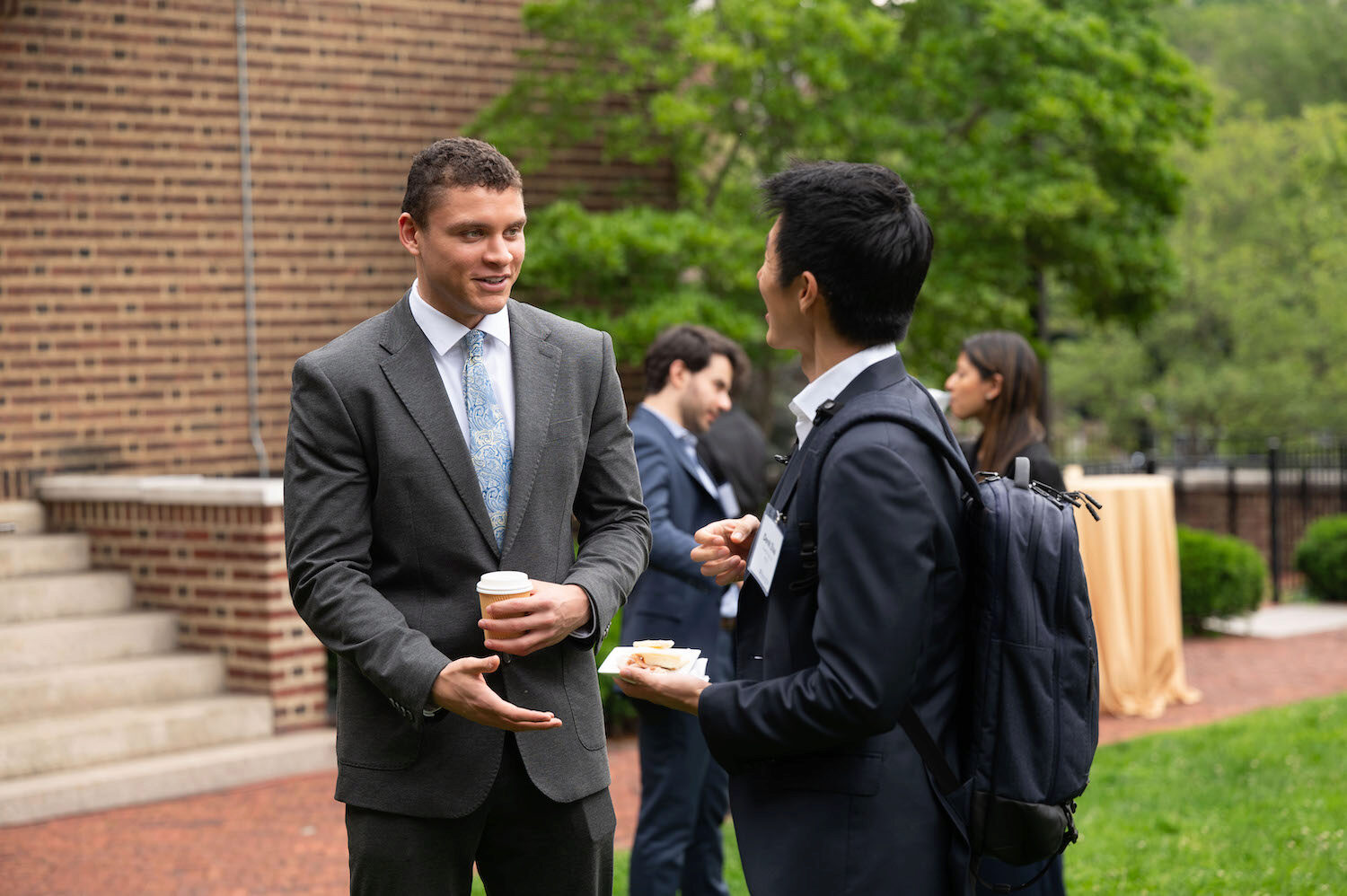 Two people networking at a conference in an outdoor setting
