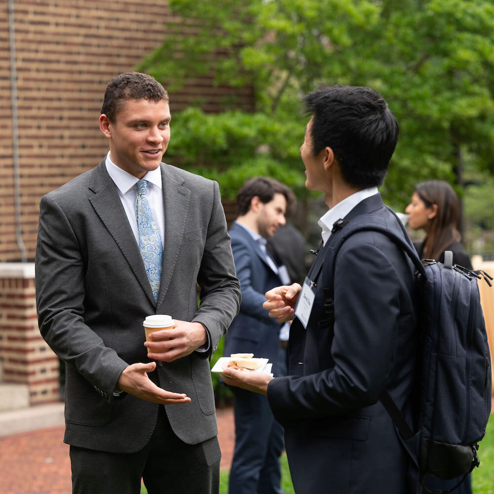 People speaking and networking at an event in an outdoor setting