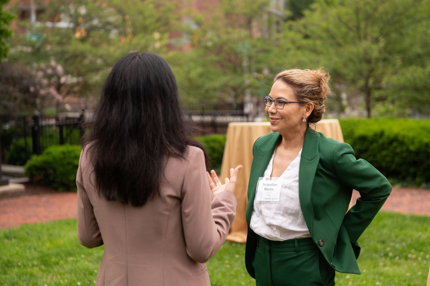 Two people speaking in an outdoor courtyard