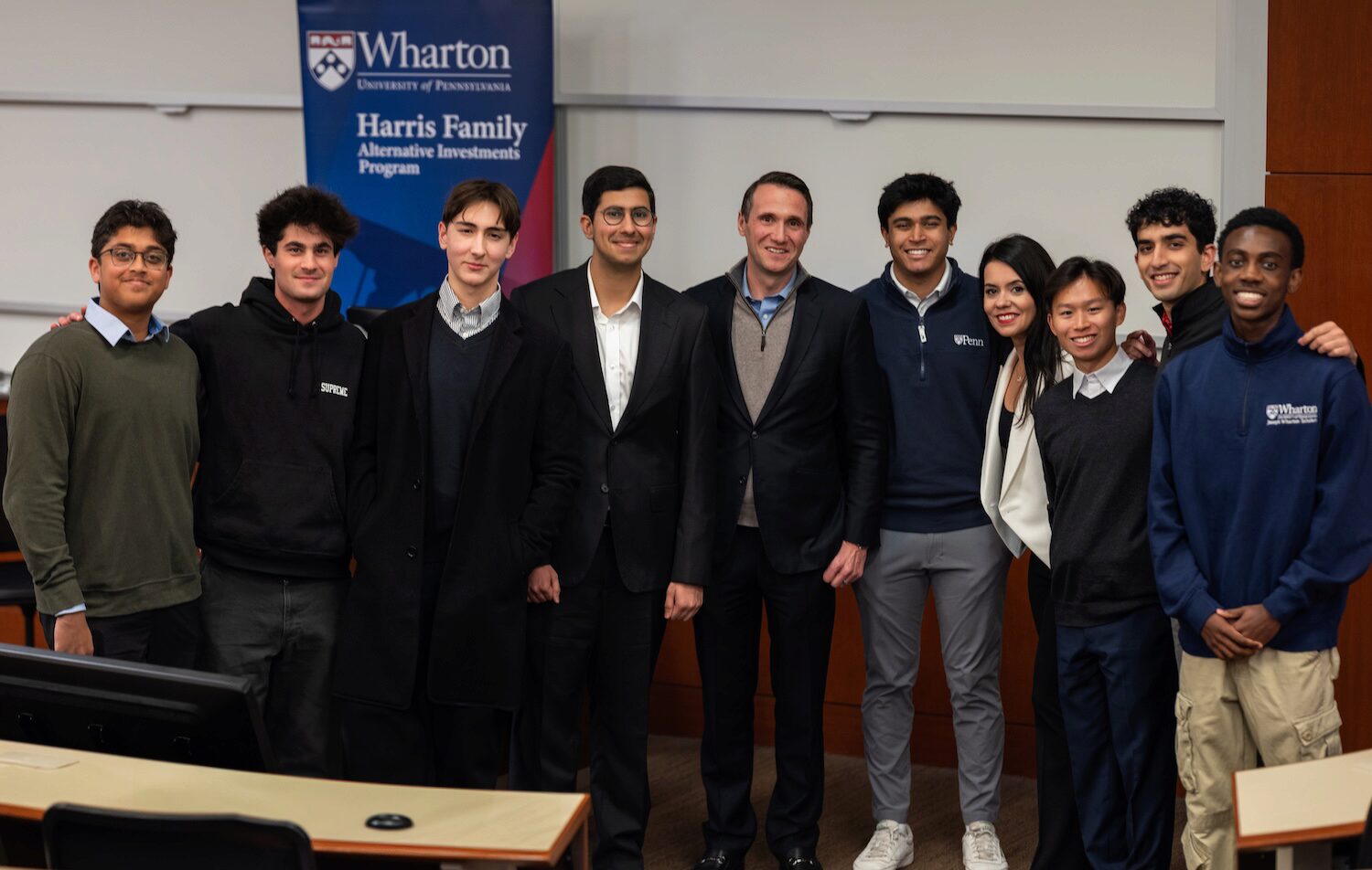 People pose for a group photo in a classroom